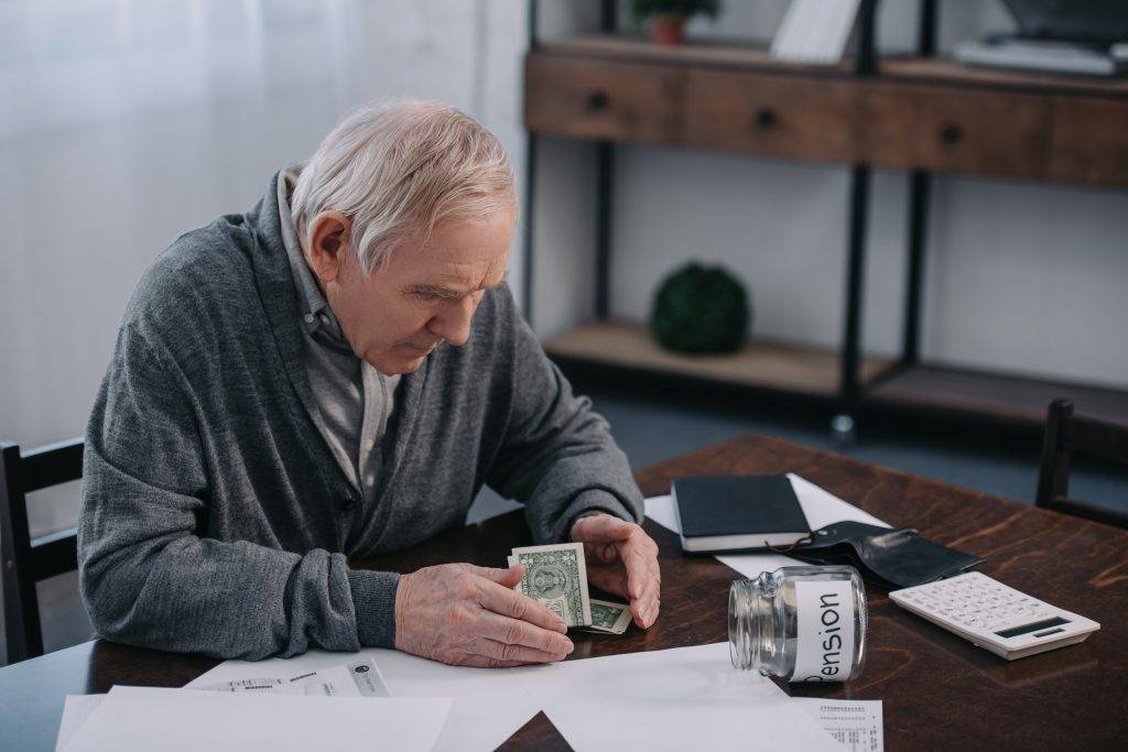 senior man sitting at table with money paperwork 2022 12 16 18 48 27 utc